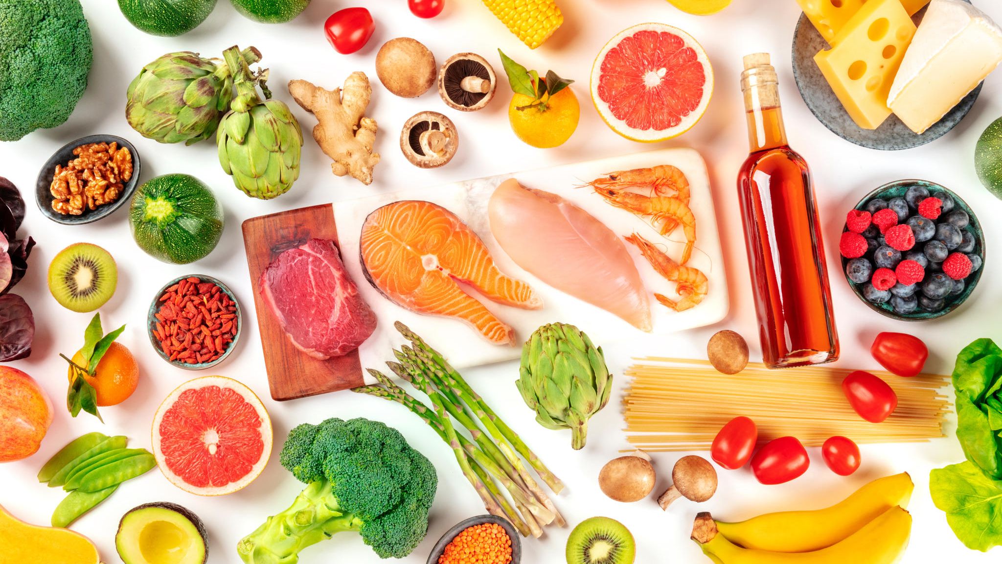 Verschieden bunte Lebensmittel liegen auf einem Tisch Verschieden bunte Lebensmittel liegen auf einem Tisch