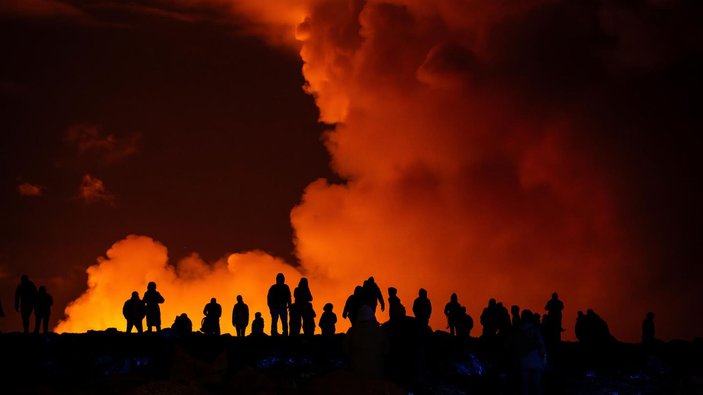 Island, Grindavík: Schaulustige beobachten die Rauchschwaden vulkanischer Aktivität im März 2024