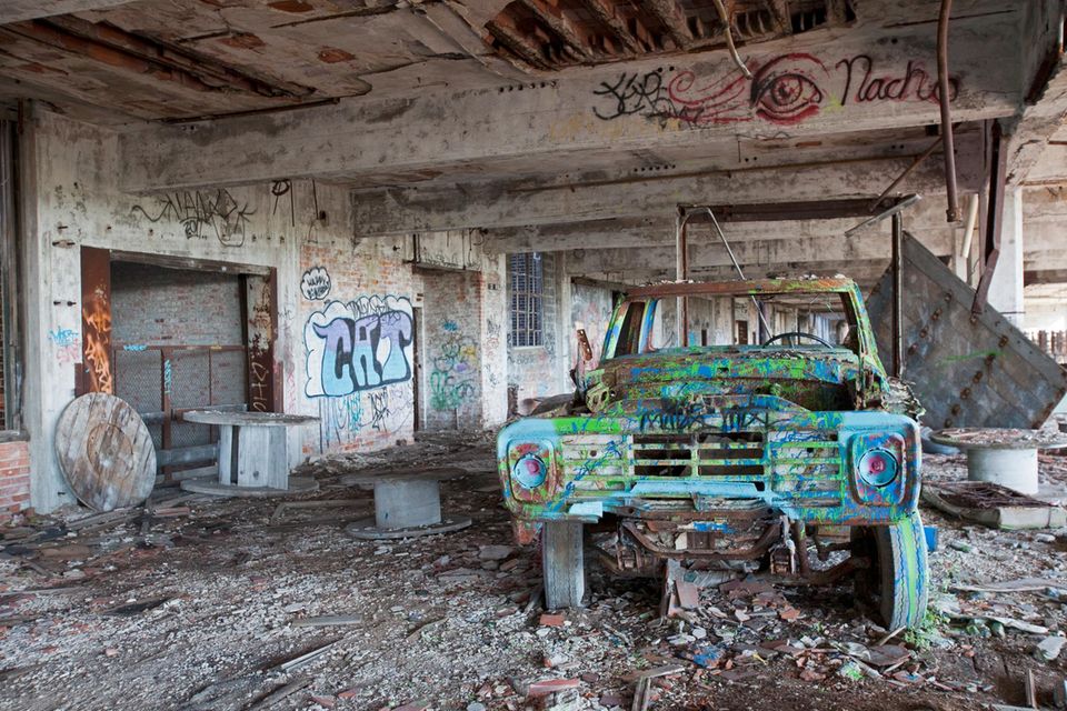Altes verottetes und verschrottetes Auto in abgestandener Halle