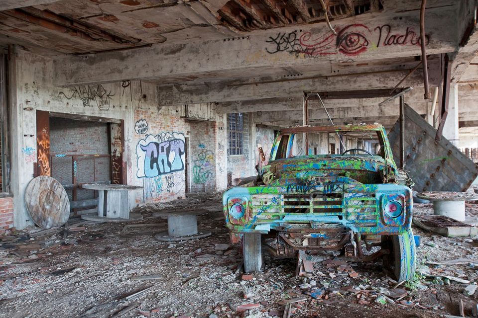 Altes verottetes und verschrottetes Auto in abgestandener Halle  1.5004