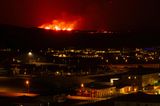 Die Eruption und das rote Glühen der Lava sind von der evakuierten Stadt Grindavik aus zu sehen