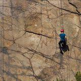 Kletterer mit Sicherheitsseil an einer Steinwand
