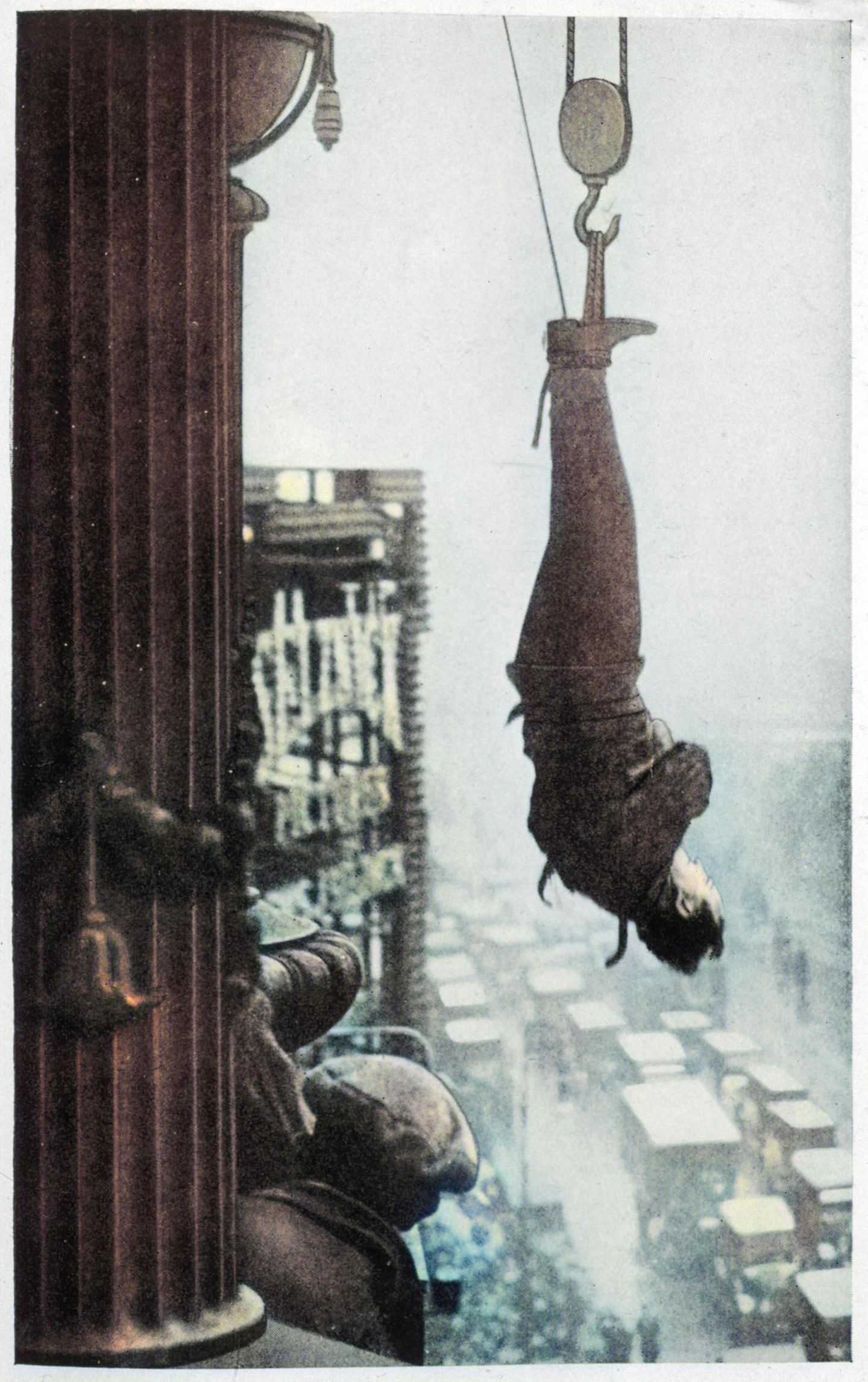 Houdini hängt kopfüber und gefesselt an einem New Yorker Skyscrper. Tief unter ihm stauen sich Autos auf der Straße