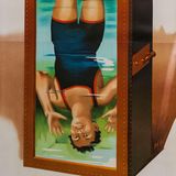 Ein buntes, gemaltes Reklame-Plakat zeigt Houdini kopfüber in einem Wassertank