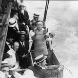 Umringt von Zuschauern steht Houdini in einer Holzkiste über dem East River und präsentiert seine Fesseln