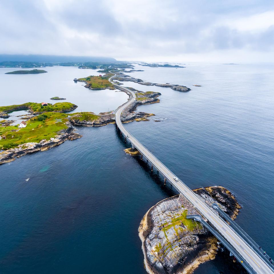 Eine geschlängelte Straße umgeben vom Ozean und wenige begrünten Landflächen