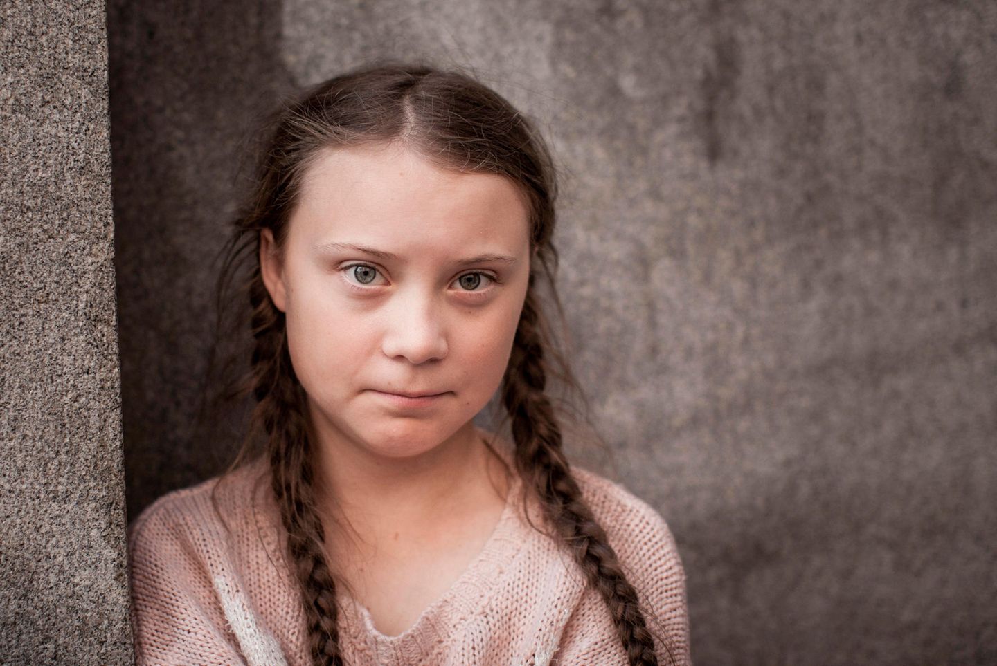 Greta Thunberg, ein Mädchen mit geflochtenen Zöpfen, schaut in die Kamera