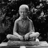 Statue von Louis Braille als Kind im Schneidersitz