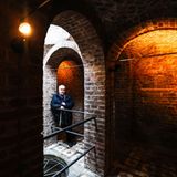 Ein Mann steht in einem Bogengang aus gemauerten Ziegeln