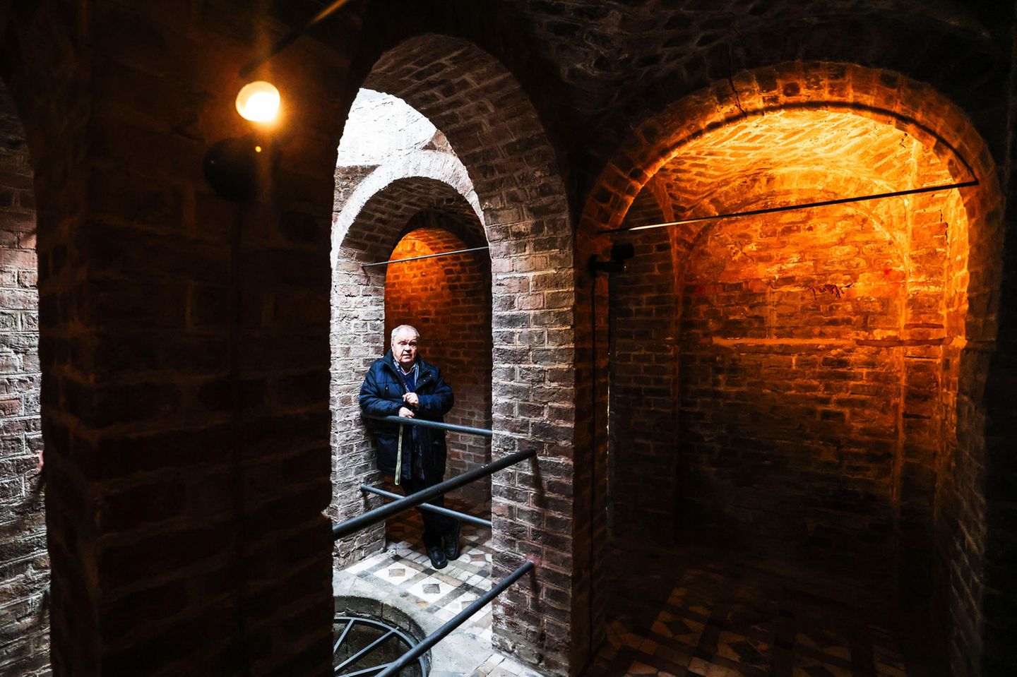 Die Aura einer Kapelle Ein Mann steht in einem Bogengang aus gemauerten Ziegeln