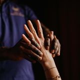 Zwei Hände von unterschiedlichen Menschen, eine massiert die andere