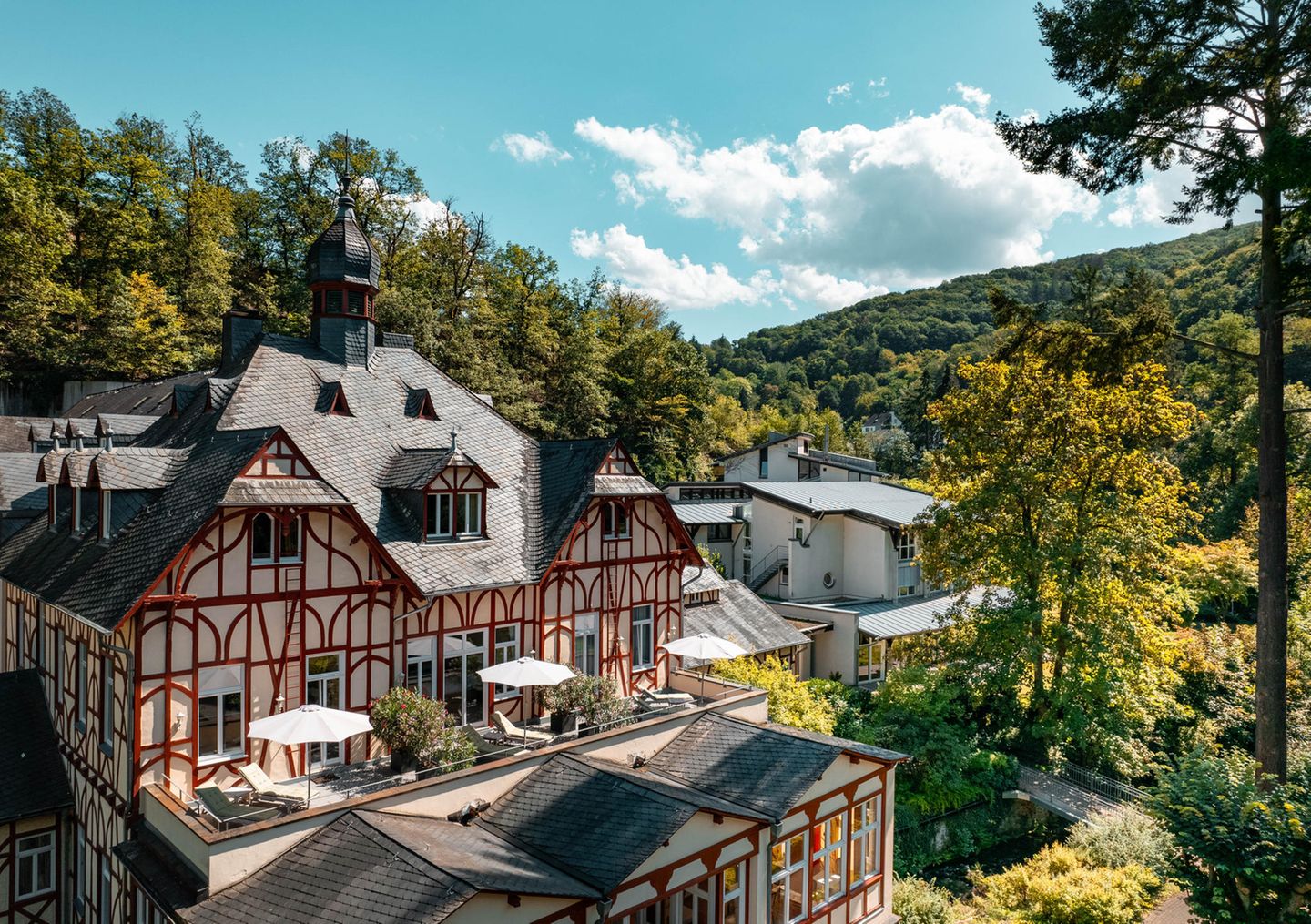 Fachwerkhaus zwischen bewaldeten Hügeln, Sommerstimmung