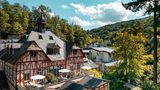 Fachwerkhaus zwischen bewaldeten Hügeln, Sommerstimmung