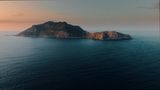 Eine Insel umgeben vom ruhigen Wasser mit den letzten Lichtstrahlen
