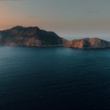 Eine Insel umgeben vom ruhigen Wasser mit den letzten Lichtstrahlen