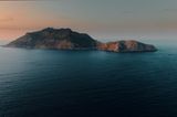 Eine Insel umgeben vom ruhigen Wasser mit den letzten Lichtstrahlen