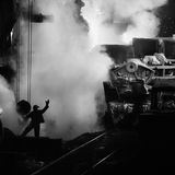 Stahlerzeugung ist eine grundlegende Produktionstechnik. Das Metall ist nicht nur Grundstoff des Transport- und Bauwesens – ohne Stahl würde die komplette Wirtschaft vieler Länder zusammenbrechen. 1987 fotografierte Salgado  im ukrainischen Stahlwerk Saporischschja: Ein Arbeiter überwacht das Ausgießen glühenden Spezialstahls in Transportloren; aus ihm werden später Bleche für die Autoindustrie gewalzt.    