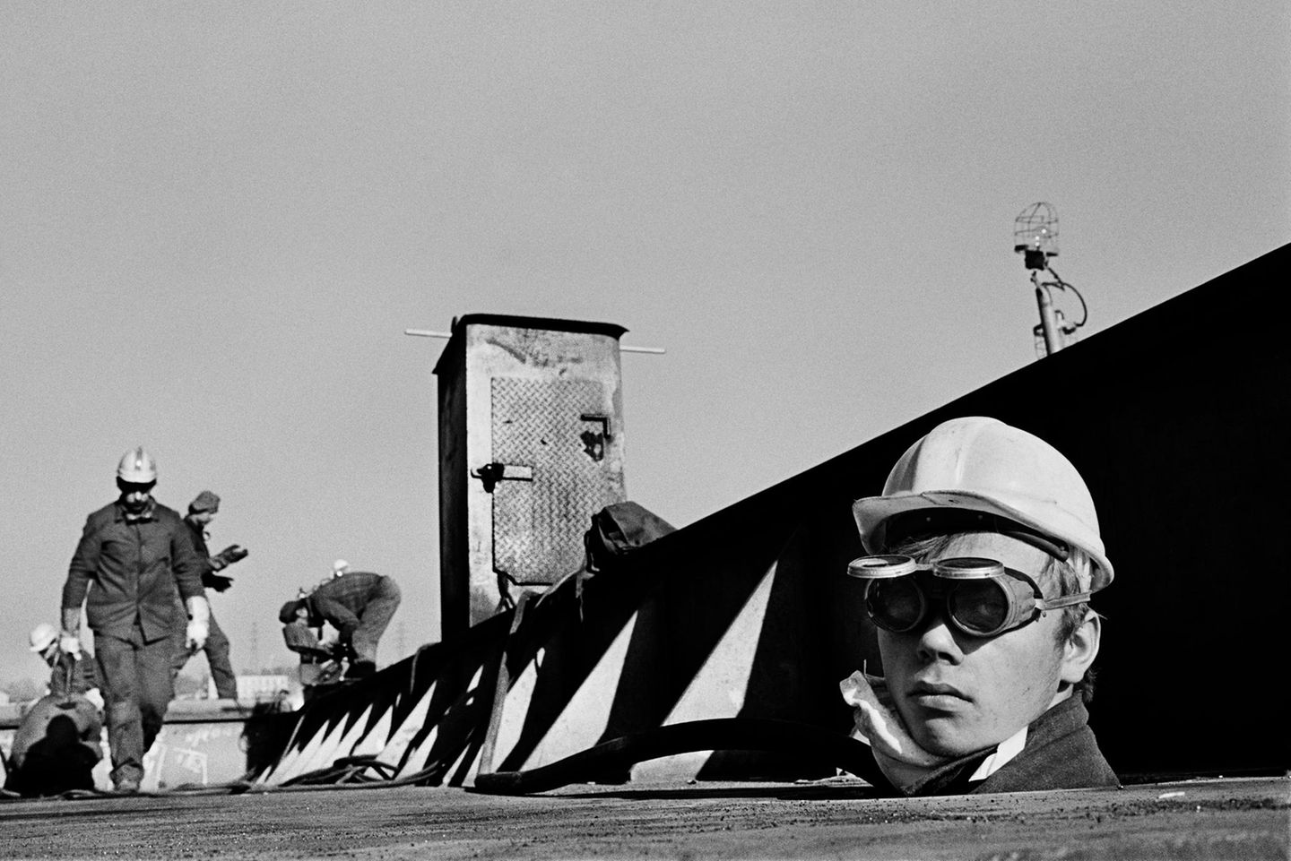 Natürlich zieht es den Dokumentierer Salgado auch zu historischen Orten: In der Danziger Schiffswerft wurden in den 1980er Jahren jene Arbeitskämpfe ausgetragen, die schließlich zur Gründung der Gewerkschaft Solidarność führten und, indirekt, auch zum Zusammenbruch des kommunistischen Machtblocks in Europa.   Dieses Bild ist, für Salgados Verhältnisse, in seiner Perspektivenwahl gerade zu humoristisch: Ein Arbeiter schaut im Trockendock der Danziger Werft aus dem Unterdeck eines gigantischen Gefriertrawlers. 