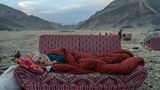 Bett im Freien: Mitten in der Wüste ruht sich eine Afghanin auf einem behelfsmäßigen Schlafplatz aus. In der Nähe liegt ein Lager, in dem kürzlich aus Pakistan abgeschobene Menschen untergebracht sind, nahe der pakistanisch-afghanischen Grenze. Seit die Taliban im August 2021 an die Macht kamen, wird die bereits vom Krieg zerstörte Wirtschaft weiterhin durch den Abzug ausländischer Hilfe beeinträchtigt. Eine vierjährige Dürre und zwei schwere Erdbeben haben die Krise verschärft. Die UN schätzt, dass 97 Prozent der afghanischen Bevölkerung unterhalb der Armutsgrenze leben. Die Zahl der Vertriebenen liegt bei über sechs Millionen.