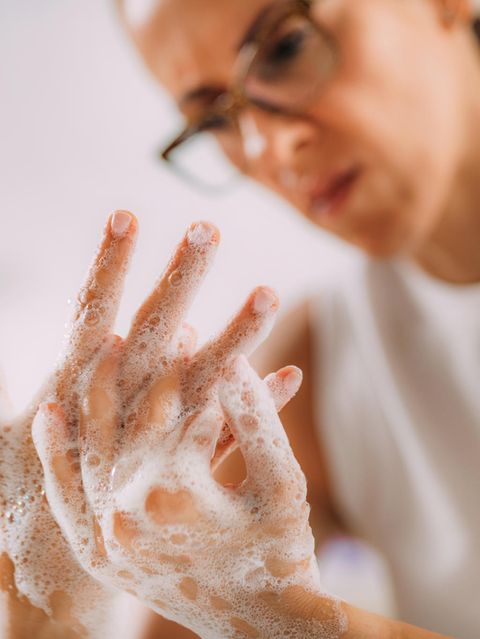 Frau seift sich mit angestrengtem Gesicht die Hände ein