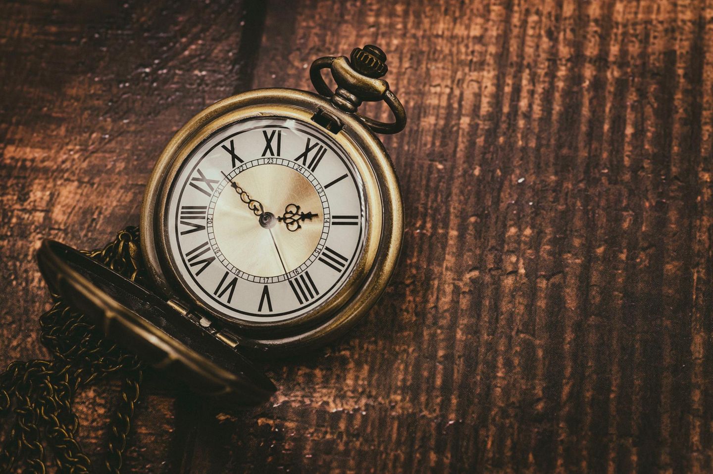 alte, goldene Vintage-Taschenuhr auf hölzernem Untergrund