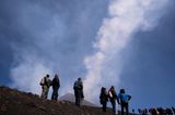 Menschen beobachten Wirbelringe am Himmel über dem Ätna