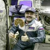 Der russische Kosmonaut Juri Usatschew mit einer Pizza auf der ISS