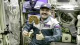 Der russische Kosmonaut Juri Usatschew mit einer Pizza auf der ISS