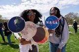 Zwei junge Frauen mit Bildern von Sonne, Mond und Erde