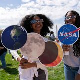 Zwei junge Frauen mit Bildern von Sonne, Mond und Erde