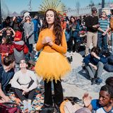 Eine Frau meditiert im Sonnen-Kostüm