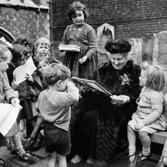 Maria Montessori umringt von Kindern