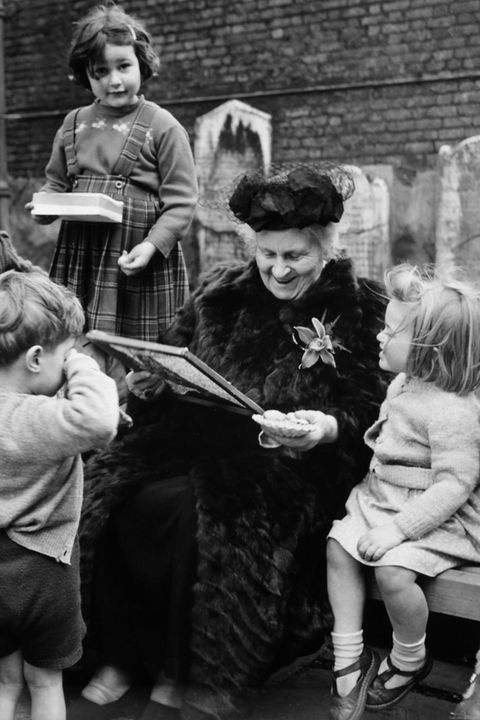 Maria Montessori umringt von Kindern