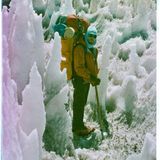 Ein Mensch blickt in die Kamera, zwischen gewaltigen Eiszapfen
