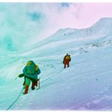 Zwei Menschen klettern am Seil den Berg hoch