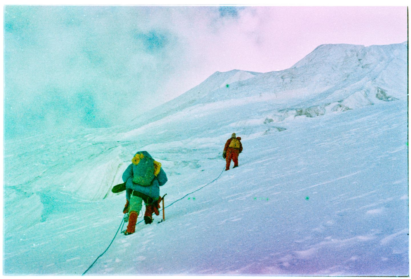 Zwei Menschen klettern am Seil den Berg hoch
