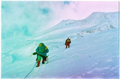 Zwei Menschen klettern am Seil den Berg hoch