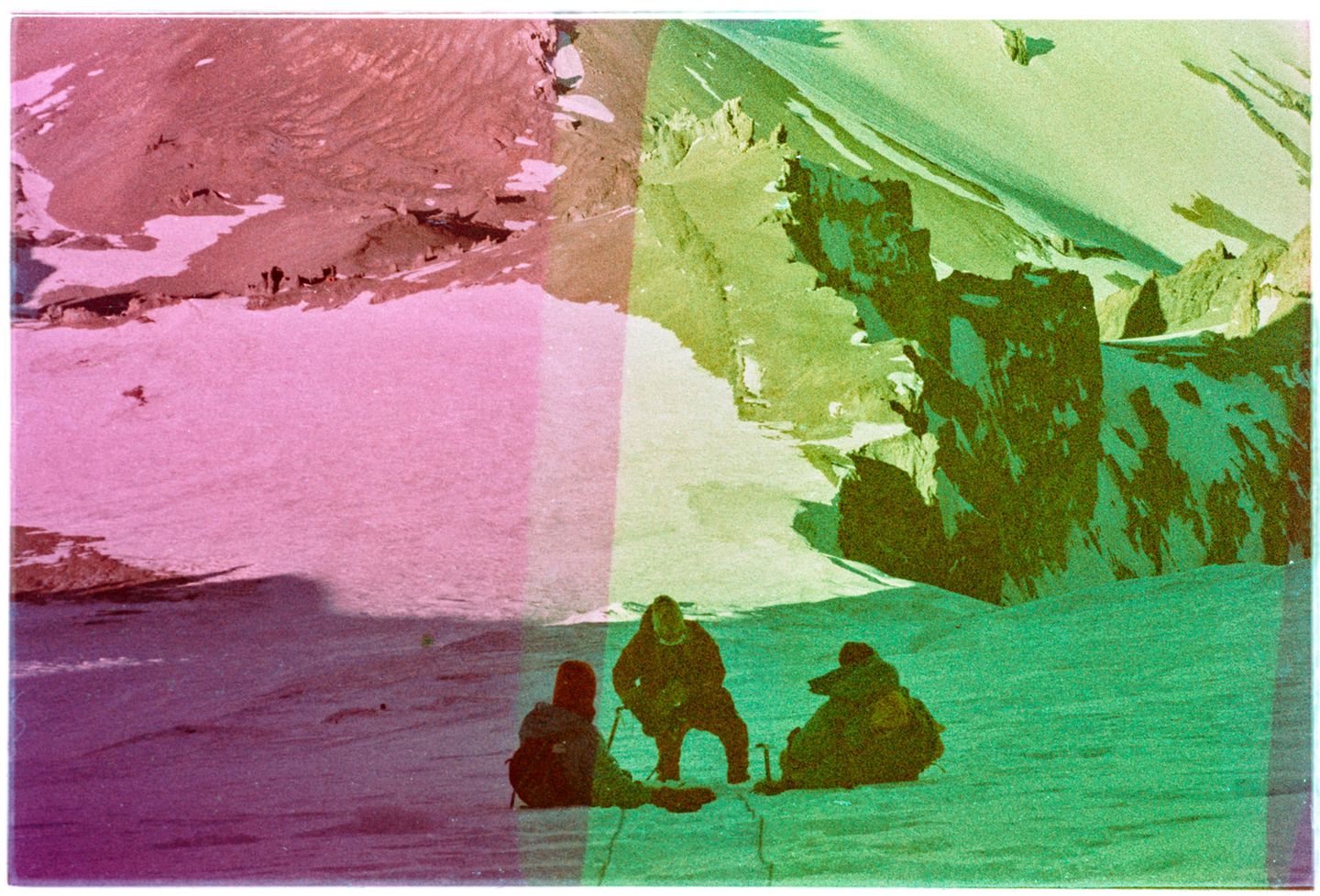 Drei Menschen sitzen und knien im Schnee an Seilen zum klettern