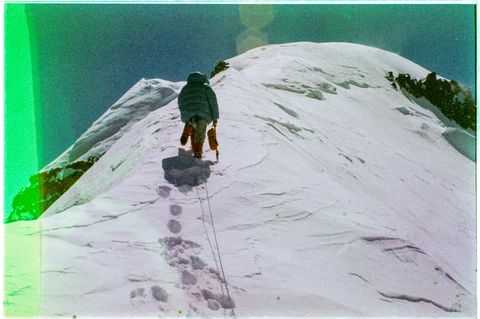 EIne Person klettert den Berg hoch und hinterlässt dabei Fußabdrücke im Schnee
