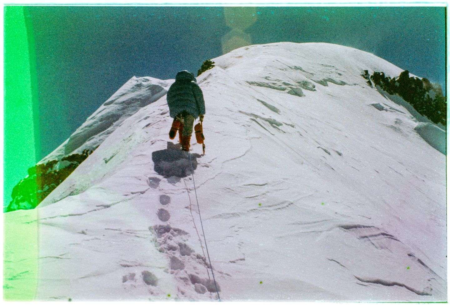 EIne Person klettert den Berg hoch und hinterlässt dabei Fußabdrücke im Schnee