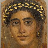 Eine junge Frau mit goldenem Haarkranz und großen Augen mit schlangenförmigen, goldenen Ohrringen