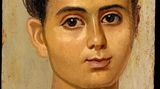 Ein Kind mit rundlichem Gesicht und weißer Tunika
