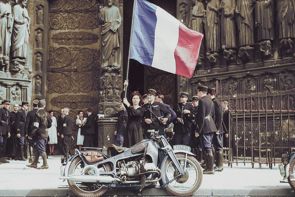 Ein Zeichen der Freiheit: Vor den Toren von Notre-Dame schwenkt eine Frau hoch erhoben die französische Nationalflagge. Als am 24. August 1944 die Glocken von Notre-Dame läuteten, verkündeten sie die Befreiung der Stadt Paris von der deutschen Besatzung. Für den Abzug der Truppen hatte Hitler die Zerstörung der Stadt und so auch der Kathedrale angeordnet. Der zuständige General Choltitz verweigerte jedoch den Befehl: Stadt und Notre-Dame blieben unversehrt. Während der Besatzung hatte die Kathedrale den Menschen in Paris halt gegeben: Hier beteten sie für die Befreiung ihres Landes 1.2298