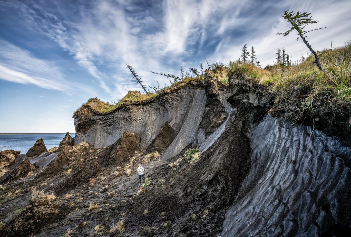 Wo der Permafrost taut, bricht das Ökosystem zusammen, und riesige Mengen CO2 und Methan werden freigesetzt. Nikita Simow, Ökologe aus Tscherskij, inspiziert einen Hangabrutsch an der Kolyma bei Duwannyj Jar. Auch die Ewenken leiden: Ihre Rentierzucht hängt von der sensiblen arktischen Natur ab
