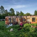 Xenia Kirillowa holt in Ijengra die Wäsche von der Leine. Das Dorf besteht aus einfachen Holzhütten, rostigen Blechbehausungen und Müll. Den Waggon nutzen die Bewohner als Lager. Die meisten der etwa 30 000 sibirischen Ewenken sind arm, viele leiden an Alkoholismus, die Selbstmordrate ist hoch