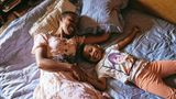 Mutter und Tochter lachen zusammen auf dem Bett