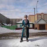 Mann steht in einer Hochhaussiedlung auf einer Strasse