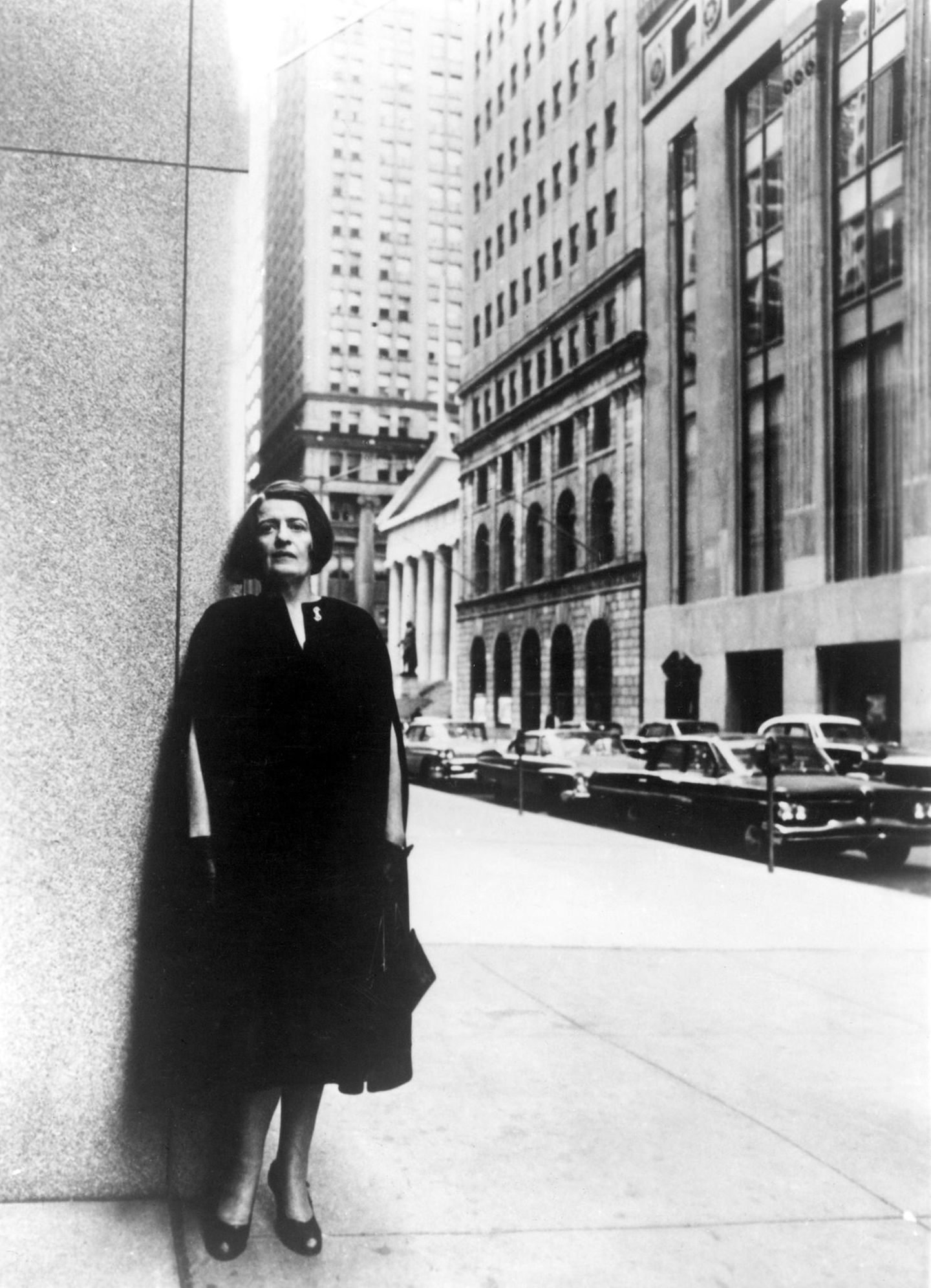 Ayn Rand lehnt an einer Wand