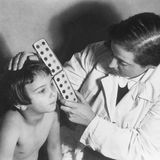 Eine Frau prüft die Augenfarbe eines Kindes