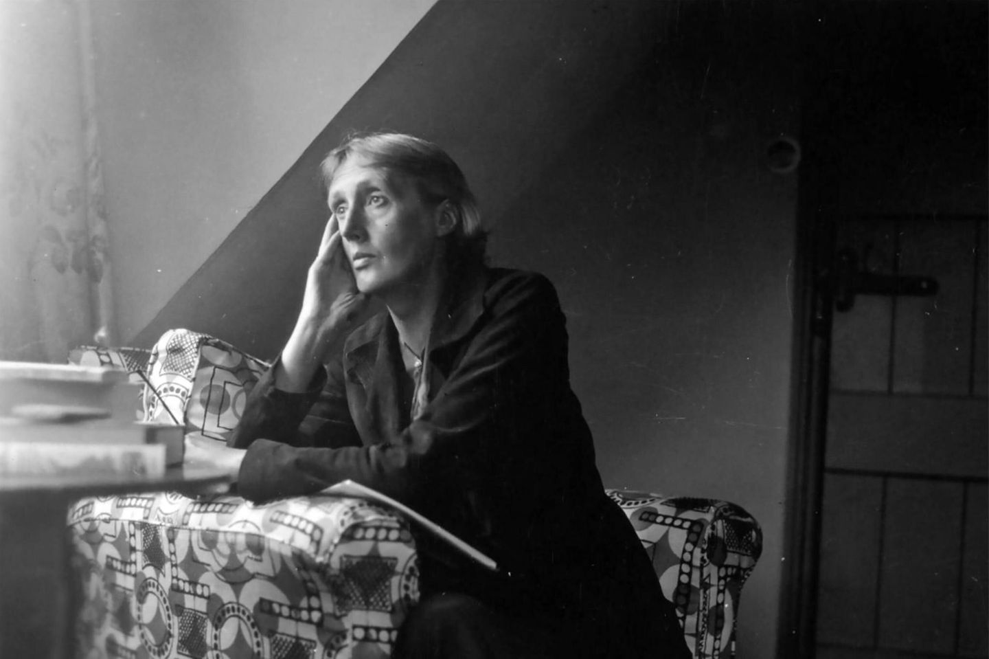 Virginia Woolf sitzt an einem Tisch